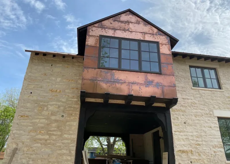 Copper metal panel facade on a stone building for Skylight Installation in Angier